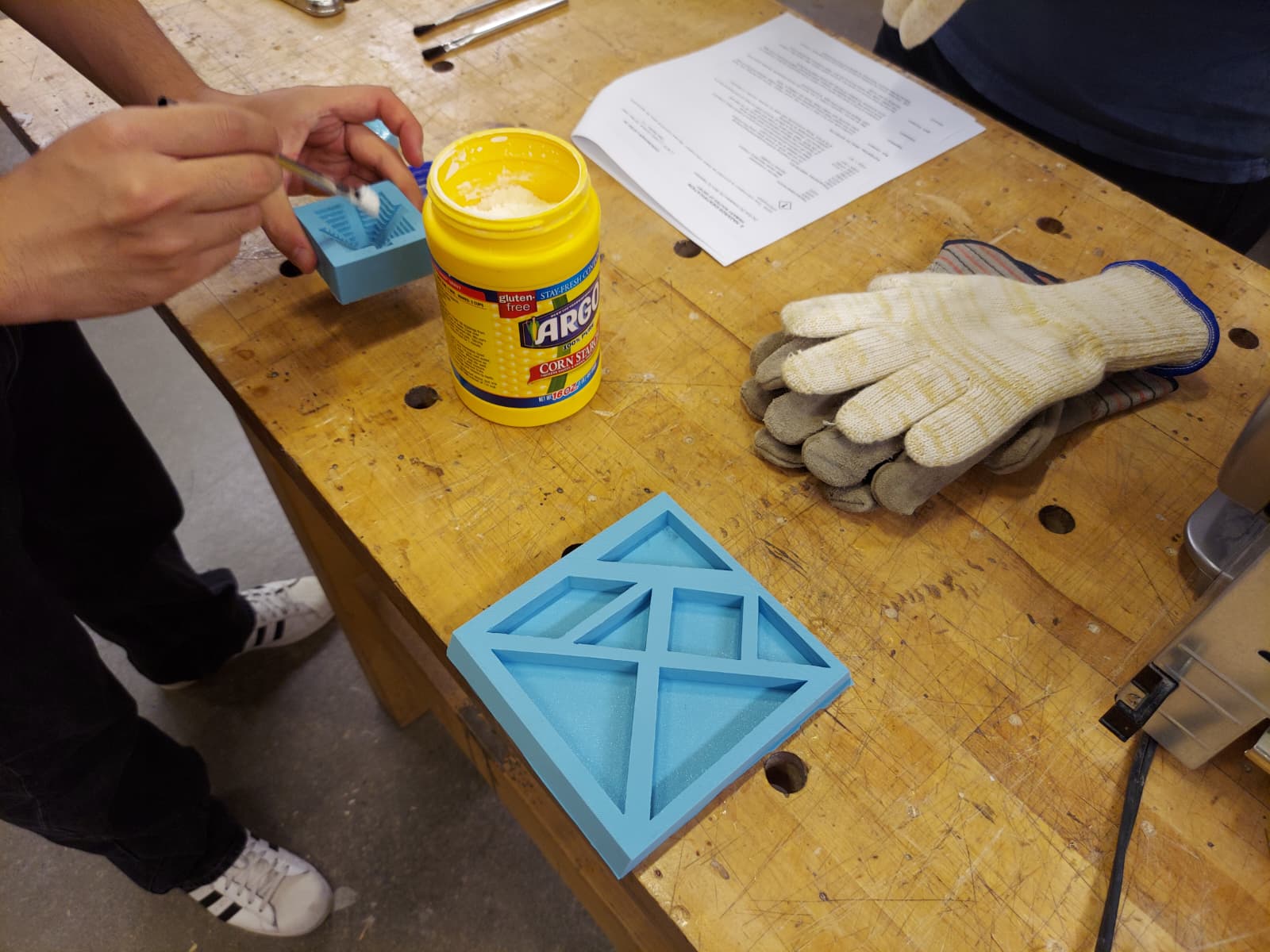 Corn starch being brushed onto silicone mold